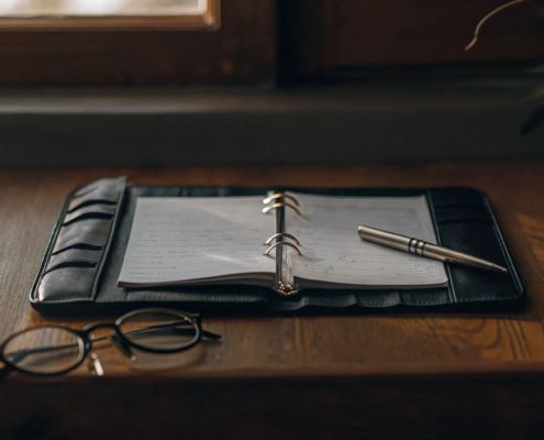 An open binder with notes and a pen, organizing the evidence needed to contest a will.
