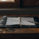 An open binder with notes and a pen, organizing the evidence needed to contest a will.