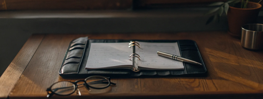 An open binder with notes and a pen, organizing the evidence needed to contest a will.