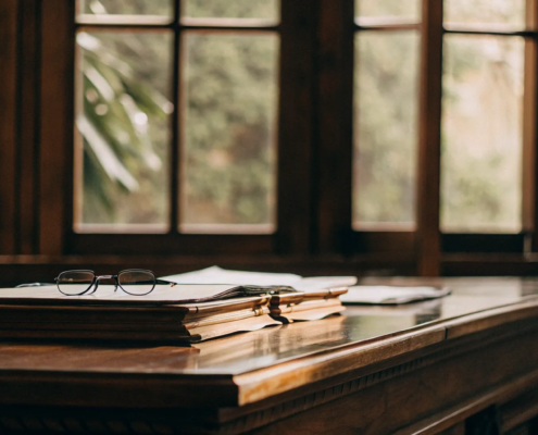 A lawyer's desk with documents and glasses for a will contest case.