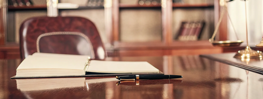 Breach of contract lawyer free consultation with justice scales and a legal binder on a desk.