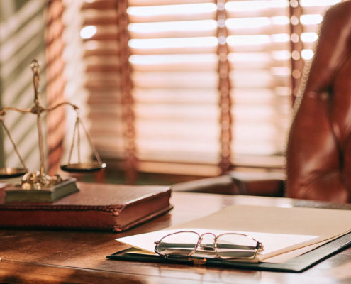 Small business lawyer's desk with scales of justice and legal documents.