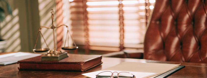 Small business lawyer's desk with scales of justice and legal documents.