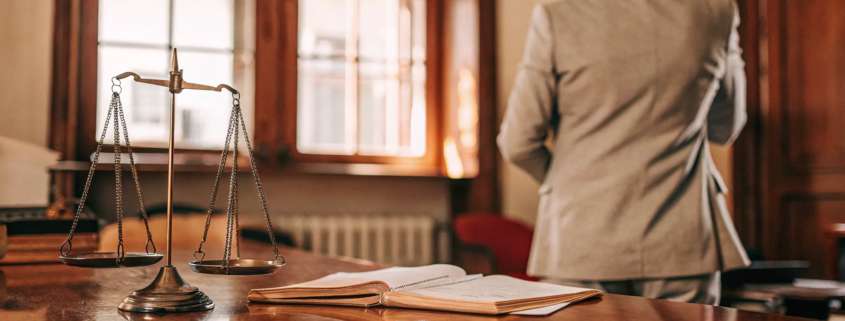 A business fraud lawyer at a desk with scales of justice, an expert to hire for your case.