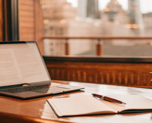 An attorney's desk with law books and a laptop for handling landlord issues.