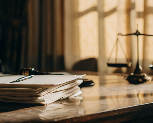 Gavel and scales of justice on a desk with papers about the cost to contest a will.