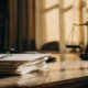 Gavel and scales of justice on a desk with papers about the cost to contest a will.