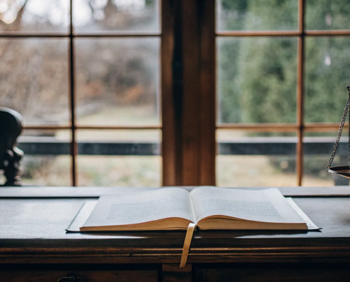 Scales of justice and a law book on a desk, weighing the decision to contest a will.