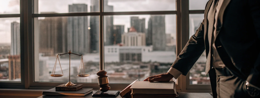 Real estate litigation attorney reviews a case file with a gavel and scales of justice on the desk.
