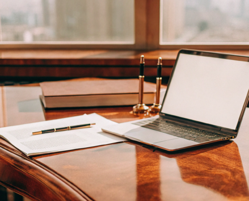 A founder's desk with a laptop and legal documents for starting an LLC.