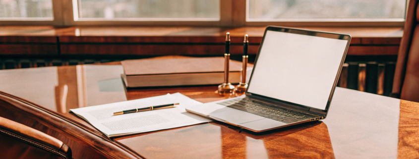 A founder's desk with a laptop and legal documents for starting an LLC.