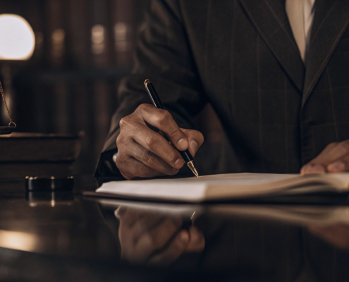 An oral contract breach attorney works on a case with scales of justice and law books on the desk.