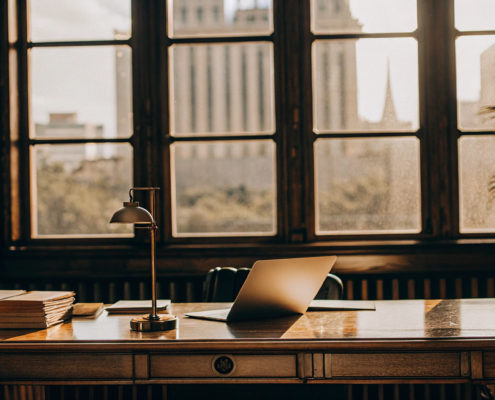 Lawyer's desk with legal books and a laptop for determining the cost of a quiet title action.