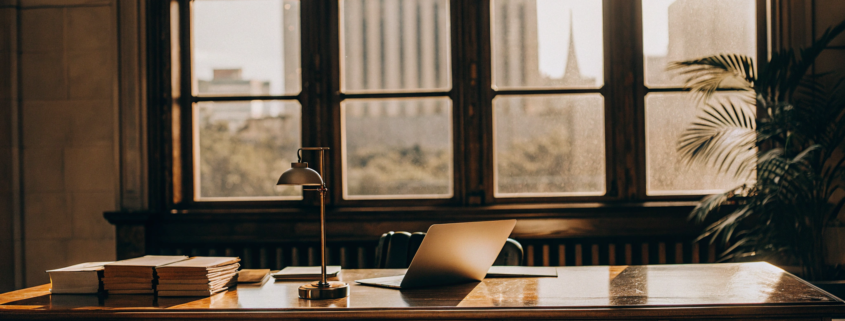 Lawyer's desk with legal books and a laptop for determining the cost of a quiet title action.