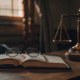 A physician employment contract lawyer's desk with a law book, gavel, and scales.