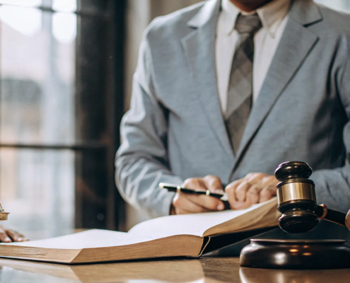 Lawyers planning a lawsuit for a money scam with a gavel and scales of justice on the desk.