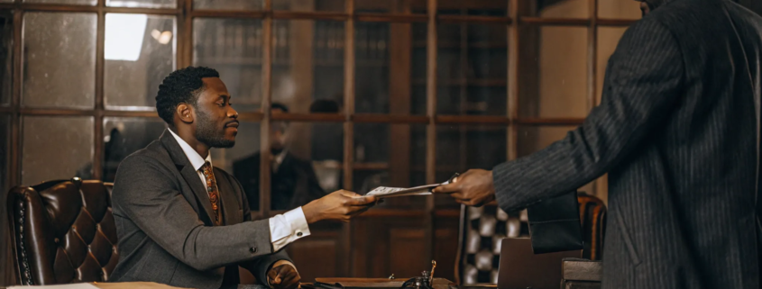 A closing attorney guides a home buyer through signing the final paperwork.