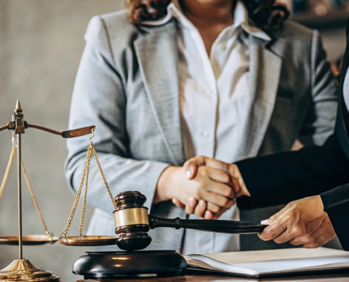 A handshake over a desk with a gavel, a key part of how to win a partition action.