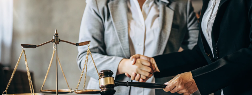 A handshake over a desk with a gavel, a key part of how to win a partition action.