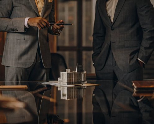 Property lawyers dealing with a real estate transaction review a building model.