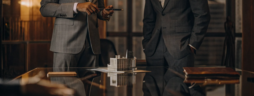 Property lawyers dealing with a real estate transaction review a building model.