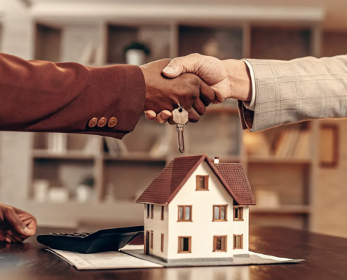 A handshake over a model home after using the realtor commission settlement website.