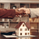 A handshake over a model home after using the realtor commission settlement website.